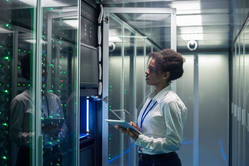 A woman holding a tablet inspects a data centre